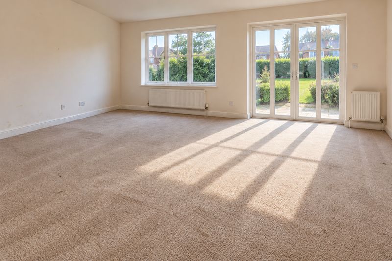 Empty living room with windows and garden doors